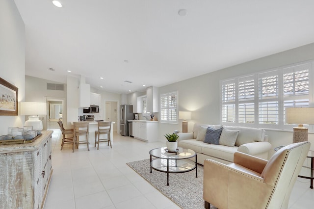 living room featuring lofted ceiling and sink