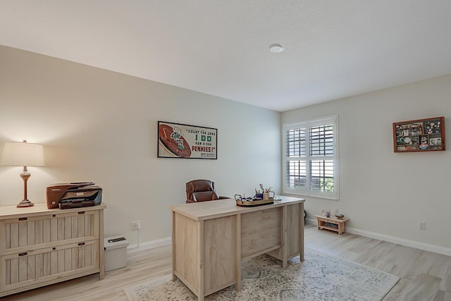 home office with light hardwood / wood-style floors