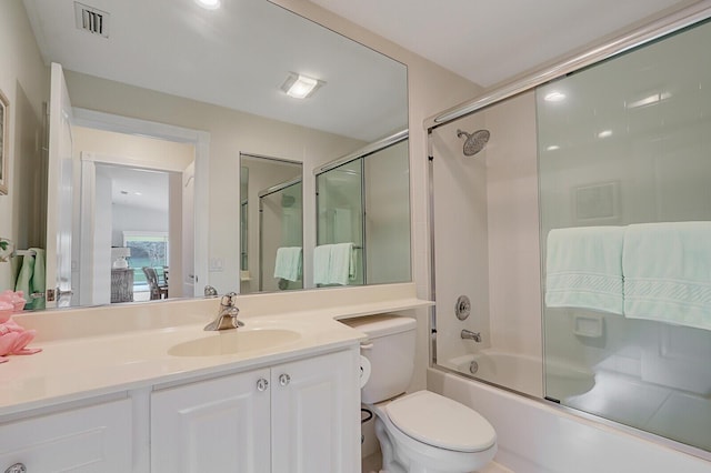 full bathroom with shower / bath combination with glass door, vanity, and toilet