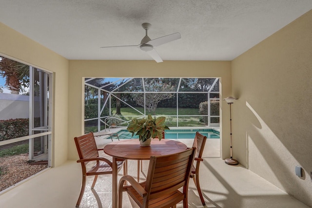 sunroom with ceiling fan and a swimming pool