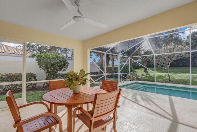 view of pool with ceiling fan, a patio, and glass enclosure