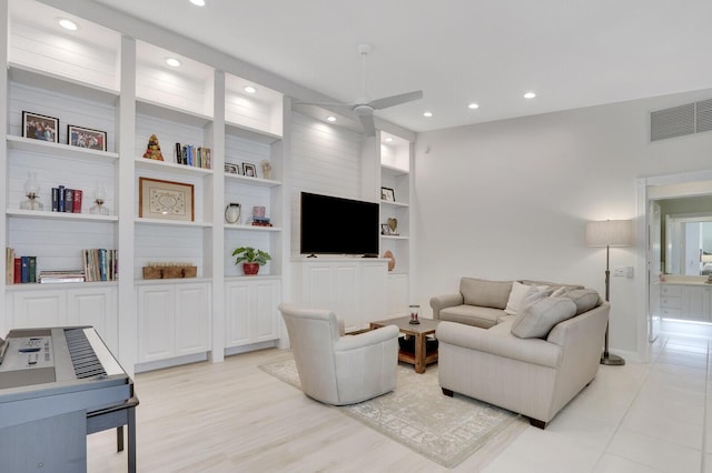 living room with built in shelves and ceiling fan