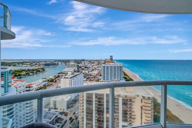 balcony featuring a water view and a beach view