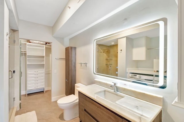 bathroom featuring a shower with door, vanity, and toilet