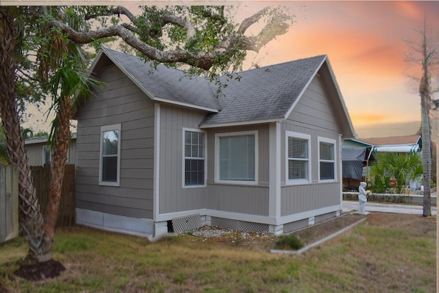 property exterior at dusk with a lawn