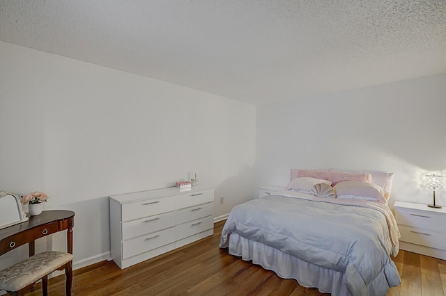 bedroom featuring wood-type flooring and a textured ceiling