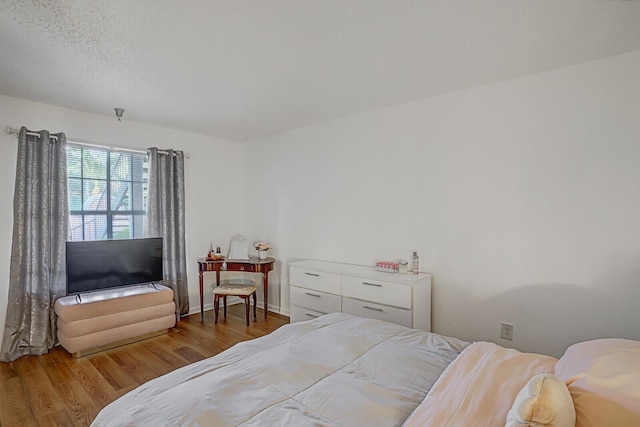 bedroom featuring hardwood / wood-style flooring and a textured ceiling