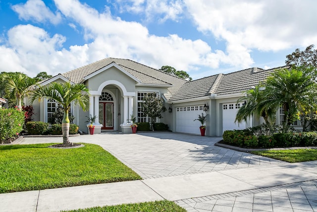 view of front of property featuring a front yard and a garage