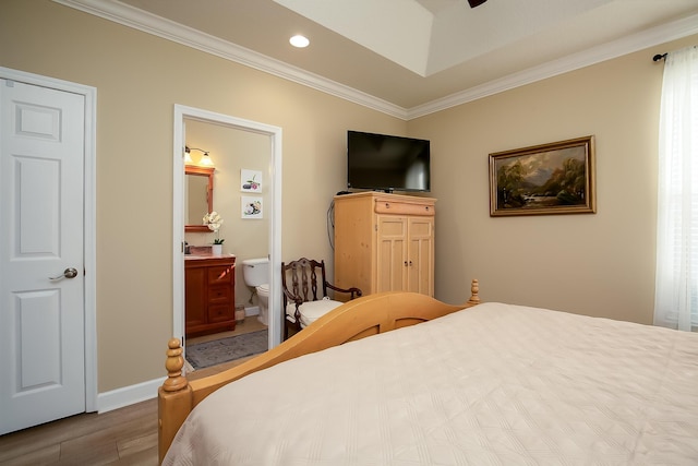 bedroom featuring connected bathroom, crown molding, and hardwood / wood-style floors