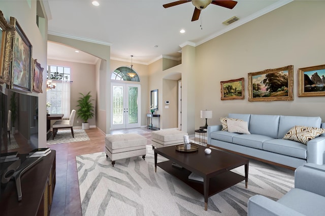 tiled living room with french doors, plenty of natural light, ornamental molding, and ceiling fan