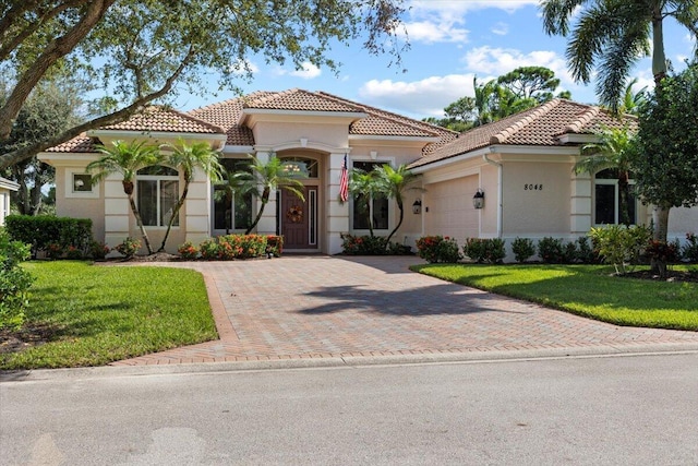 mediterranean / spanish-style house with a garage and a front yard