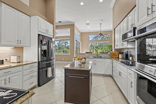 kitchen featuring backsplash, black electric cooktop, stainless steel fridge, and white cabinets