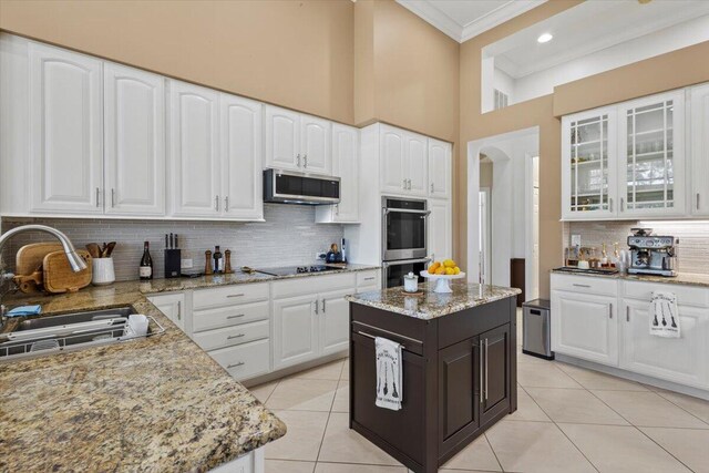 kitchen featuring appliances with stainless steel finishes, backsplash, white cabinetry, and sink