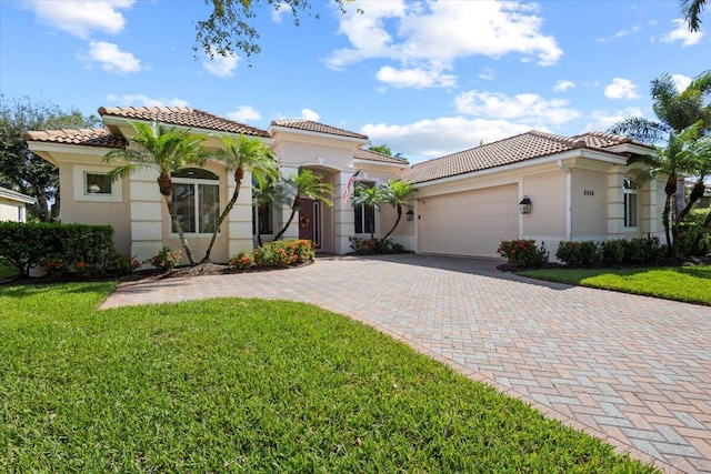 mediterranean / spanish house with a front lawn and a garage