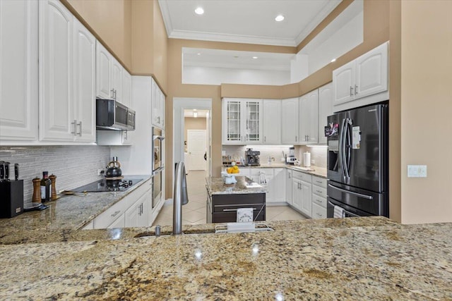 kitchen with backsplash, white cabinets, sink, light stone countertops, and appliances with stainless steel finishes