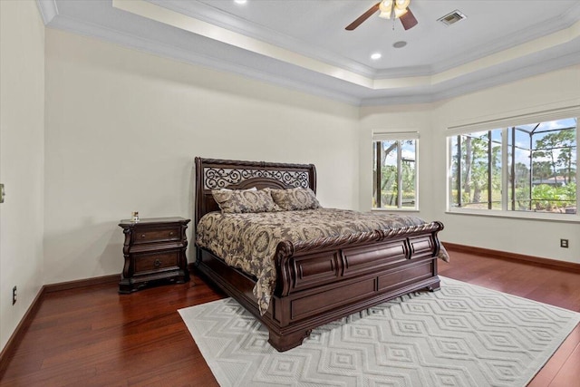 bedroom with wood-type flooring, a raised ceiling, and ceiling fan