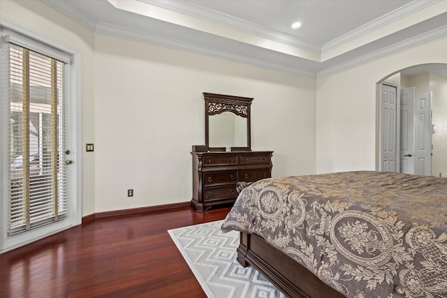 bedroom with dark hardwood / wood-style floors, crown molding, and a tray ceiling