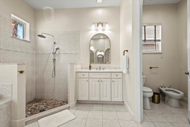 bathroom featuring tiled shower, vanity, tile patterned floors, and a bidet