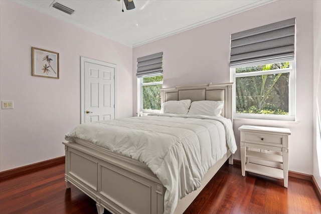 bedroom featuring ceiling fan, crown molding, and dark wood-type flooring