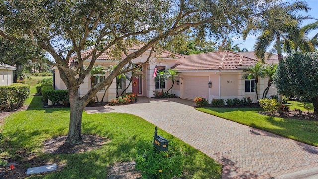 mediterranean / spanish house featuring a front yard and a garage