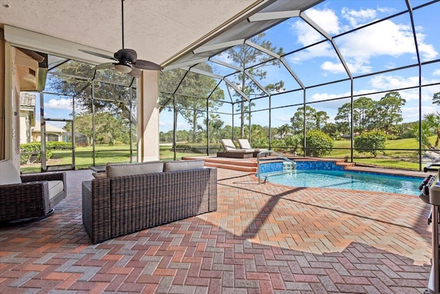 view of swimming pool featuring glass enclosure, ceiling fan, and a patio area