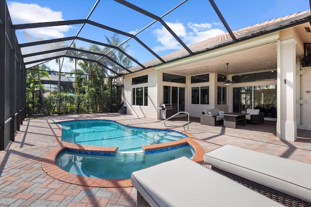 view of swimming pool with an in ground hot tub, a lanai, outdoor lounge area, ceiling fan, and a patio area