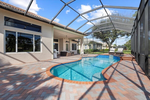 view of swimming pool featuring outdoor lounge area, glass enclosure, ceiling fan, a grill, and a patio