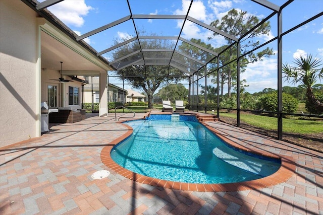 view of swimming pool featuring glass enclosure, ceiling fan, and a patio area