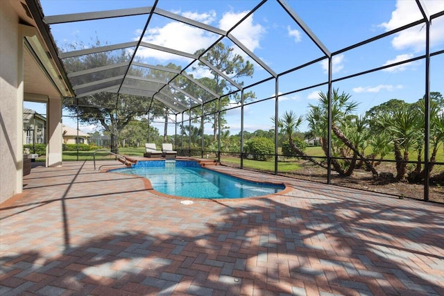 view of pool with glass enclosure and a patio