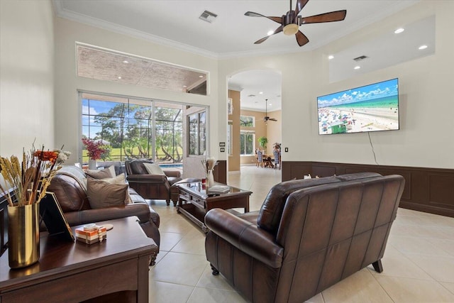 living room with ceiling fan, light tile patterned floors, and crown molding