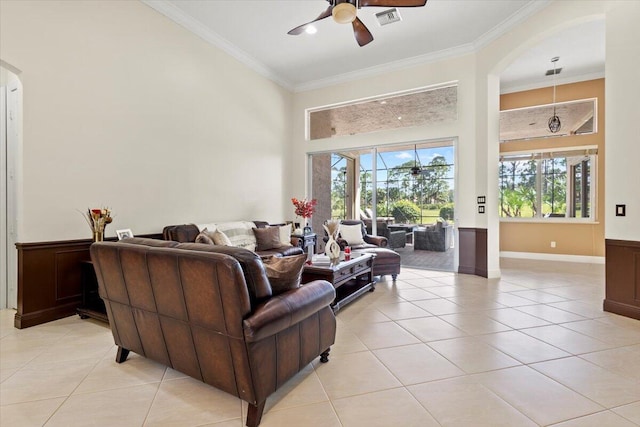 tiled living room with plenty of natural light, ceiling fan, and ornamental molding