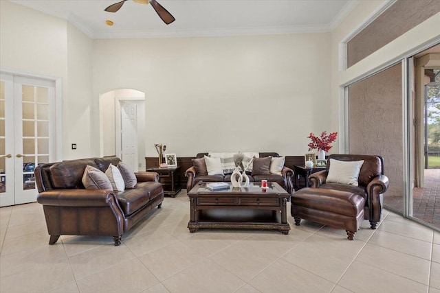 tiled living room with ceiling fan, crown molding, and french doors