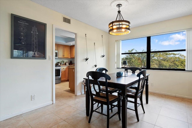 dining space with light tile patterned floors and a textured ceiling