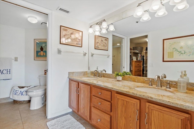 bathroom with tile patterned flooring, vanity, and toilet