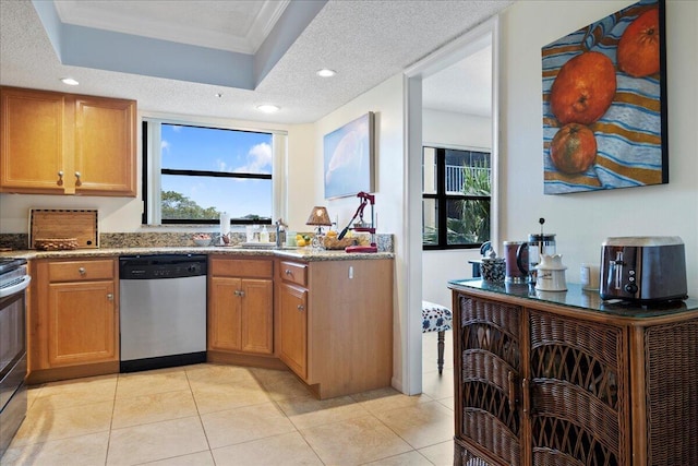 kitchen with light tile patterned floors, appliances with stainless steel finishes, light stone counters, a tray ceiling, and a textured ceiling