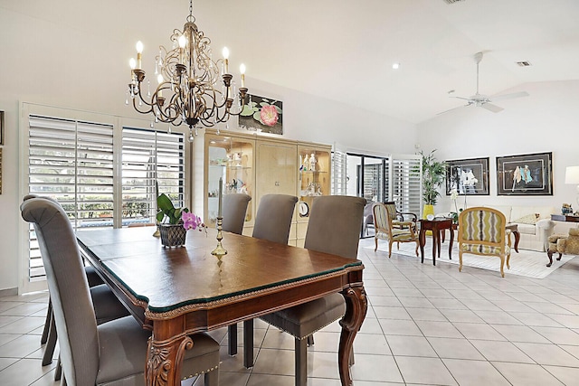 tiled dining area featuring high vaulted ceiling and ceiling fan with notable chandelier