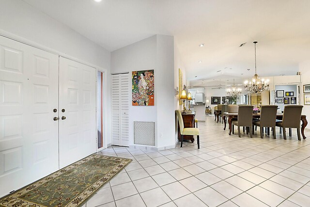 tiled dining area with ceiling fan with notable chandelier