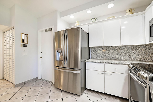 kitchen featuring decorative backsplash, light stone countertops, light tile patterned flooring, white cabinetry, and stainless steel appliances