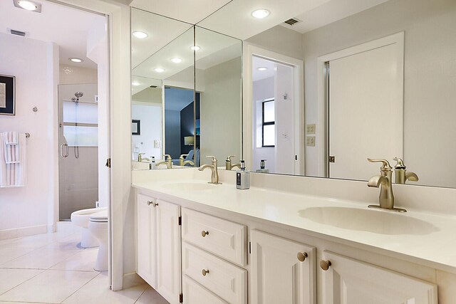 bathroom featuring tile patterned floors, vanity, toilet, and walk in shower