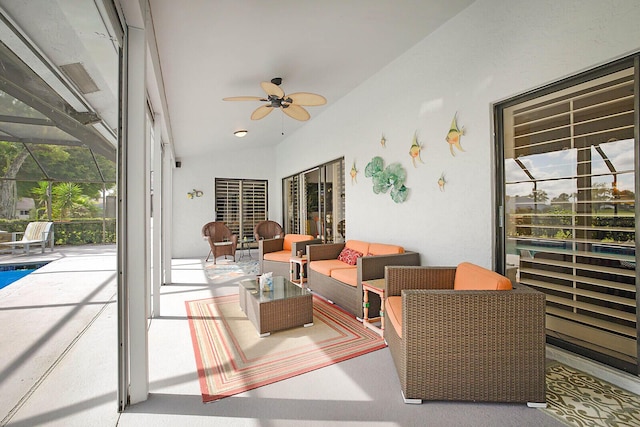 interior space with an outdoor pool, glass enclosure, ceiling fan, and outdoor lounge area