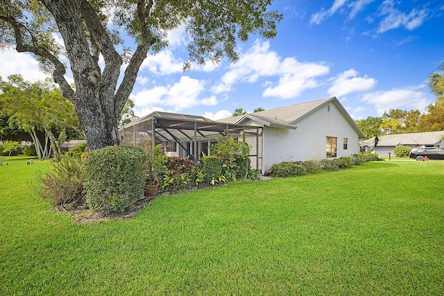 view of property exterior with a lanai, a yard, and stucco siding