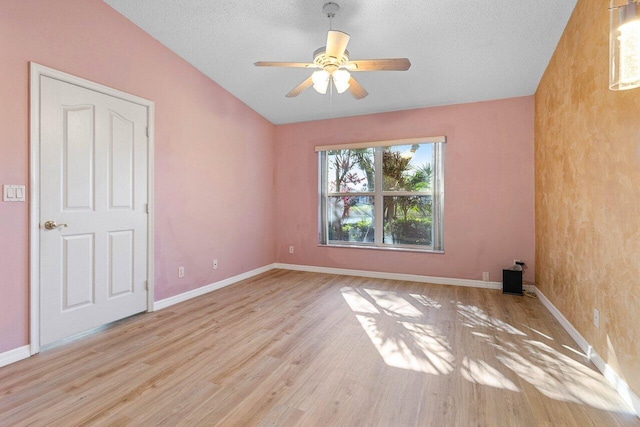 empty room with lofted ceiling, wood finished floors, and baseboards