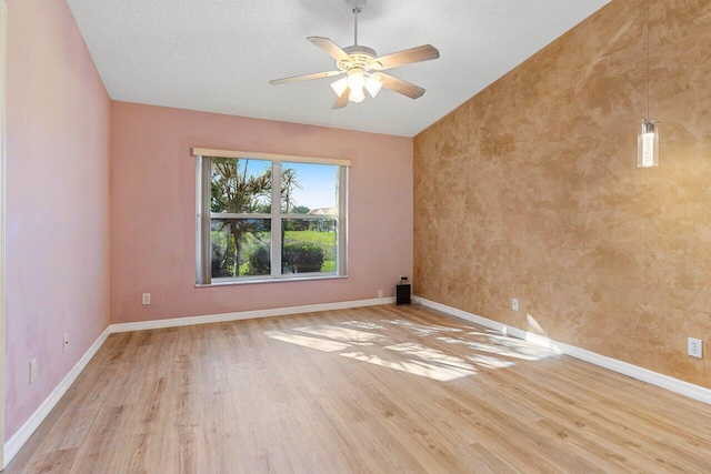 spare room with lofted ceiling, a ceiling fan, baseboards, and wood finished floors