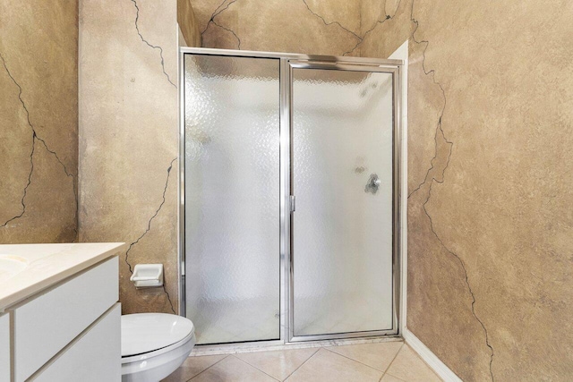 bathroom with tile patterned flooring, toilet, a shower stall, and vanity