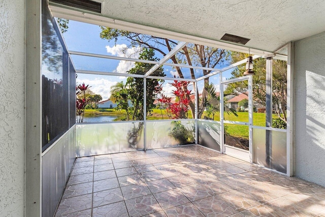 unfurnished sunroom with a water view and visible vents