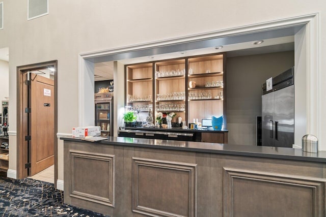 bar featuring a dry bar, high end refrigerator, tile patterned flooring, and visible vents