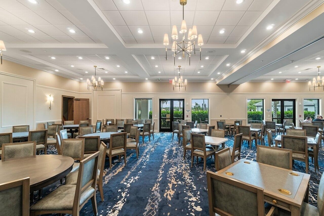 carpeted dining room with crown molding, french doors, a towering ceiling, and an inviting chandelier