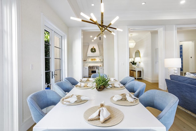 dining area featuring hardwood / wood-style flooring, a fireplace, ornamental molding, and an inviting chandelier