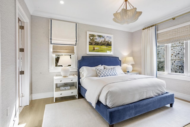 bedroom with light hardwood / wood-style flooring and crown molding