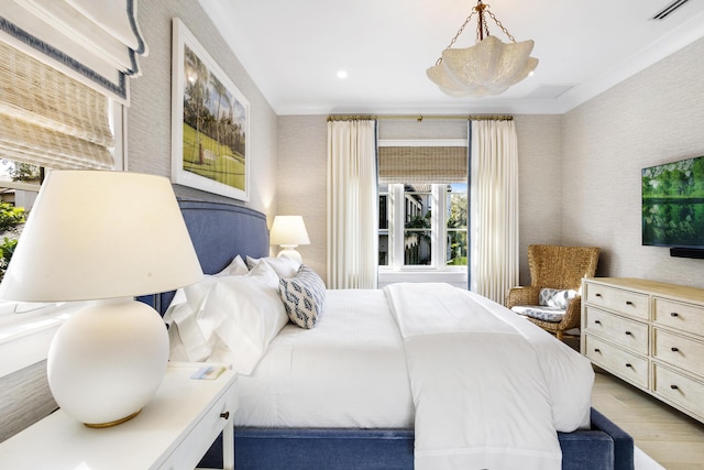 bedroom featuring light wood-type flooring and crown molding